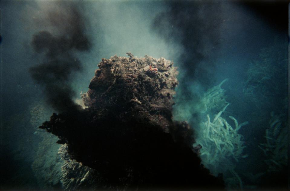 A hydrothermal vent spewing black smoke into the water.