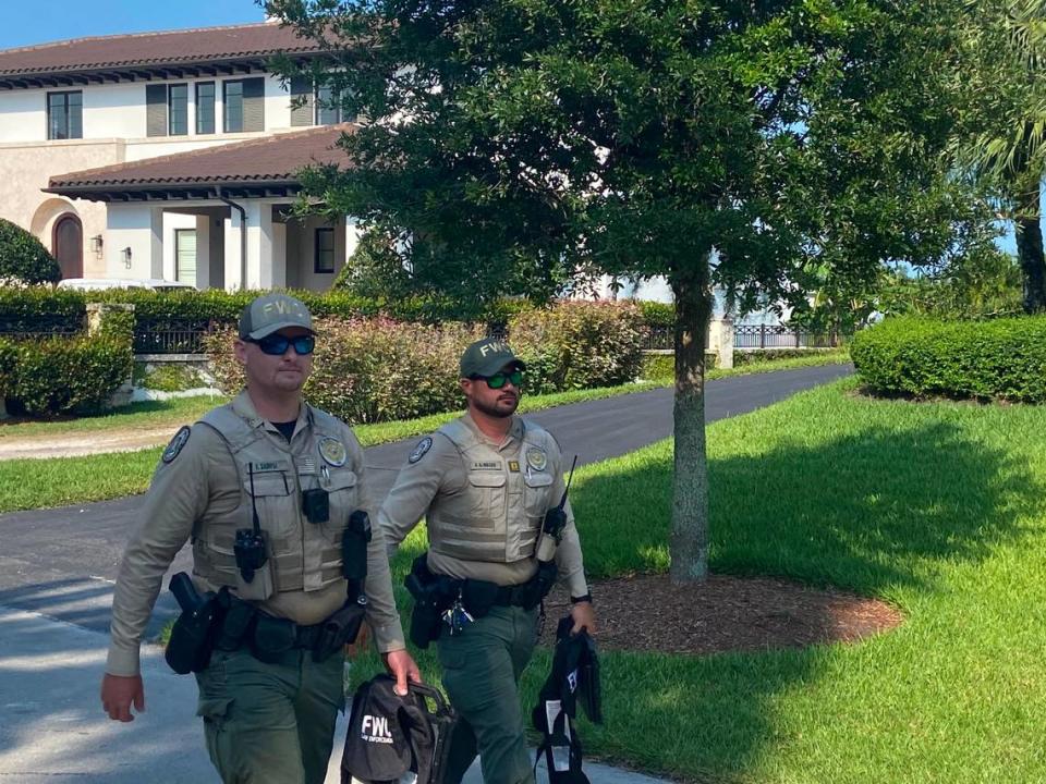 Florida Fish and Wildlife Conservation Commission officers exit the property where police say a boat matching the description of the vessel that struck and killed Ella Adler near Nixon Beach Sandbar was located.