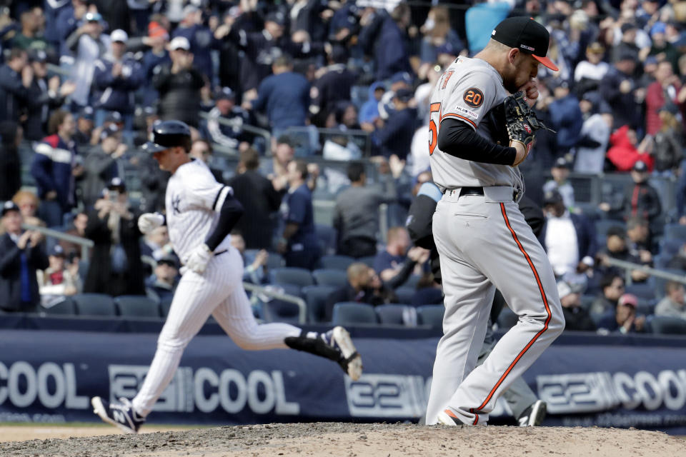 Baltimore Orioles relief pitcher Paul Fry, right, walks near the mound after giving up a solo home run to first baseman Greg Bird, left, during the eighth inning of an opening day baseball game at Yankee Stadium, Thursday, March 28, 2019, in New York. The Yankees won 7-2. (AP Photo/Julio Cortez)