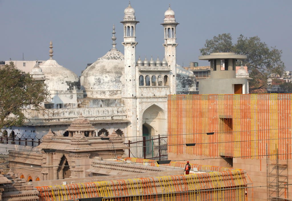 File photo: A worker stands on a temple rooftop adjacent to the Gyanvapi Mosque in the northern city of Varanasi  (Reuters)