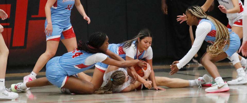 Monterey’s Ari Johnson (24) and Heaven Limon (4) and Lubbock-Cooper’s Karlee Cronk fight for a loose ball in a District 4-5A game Friday, Dec. 16, 2022 at Lubbock-Cooper High School in Woodrow, Texas.