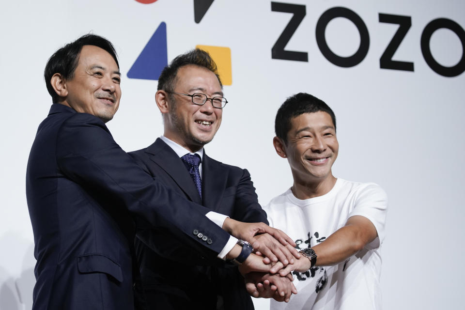 Yahoo Japan President Kentaro Kawabe, from left, Zozo's new president, Kotaro Sawada, and Zozo founder, Yusaku Maezawa, pose for photos during a news conference Thursday, Sept. 12, 2019, in Tokyo. (AP Photo/Jae C. Hong)