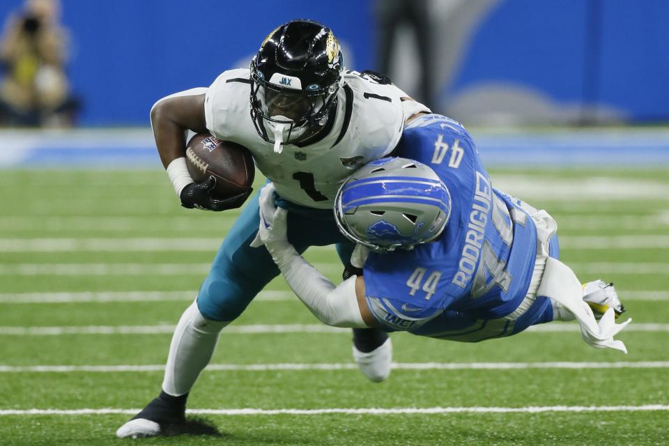 Jacksonville Jaguars running back Travis Etienne Jr. (1) is tackled by Detroit Lions linebacker Malcolm Rodriguez (44) during the first half Sunday in Detroit.