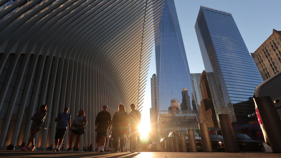 The sun sets behind the Oculus transit hub and One World Trade Center in New York City on the summer solstice in 2019. - Gary Hershorn/Corbis/Getty Images