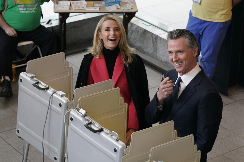 California Gov. Gavin Newsom and his wife, first partner Jennifer Siebel Newsom laugh as they pause from voting and spot photographers above, at a voting center in Sacramento, Calif., Tuesday, Nov. 8, 2022. Newsom is running for reelection against Republican state Sen. Brian Dahle. (AP Photo/Rich Pedroncelli)