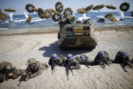 FILE PHOTO: South Korean (blue headbands) and U.S. Marines take positions as amphibious assault vehicles of the South Korean Marine Corps fire smoke bombs during a U.S.-South Korea joint landing operation drill in Pohang, South Korea, March 12, 2016. REUTERS/Kim Hong-Ji