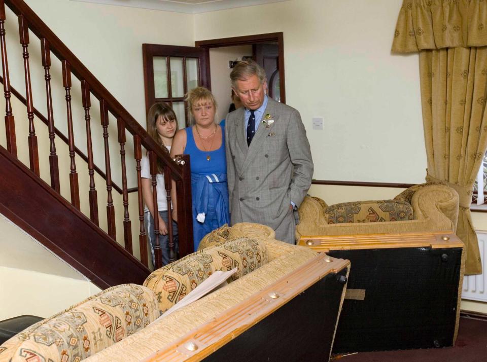 Prince Charles, Prince of Wales sees flood damage in the home of the Breeze family when he visits the village of Carcliffe in South Yorkshire to meet emergency service personnel and residents affected by the recent floods brought on by heavy rains.