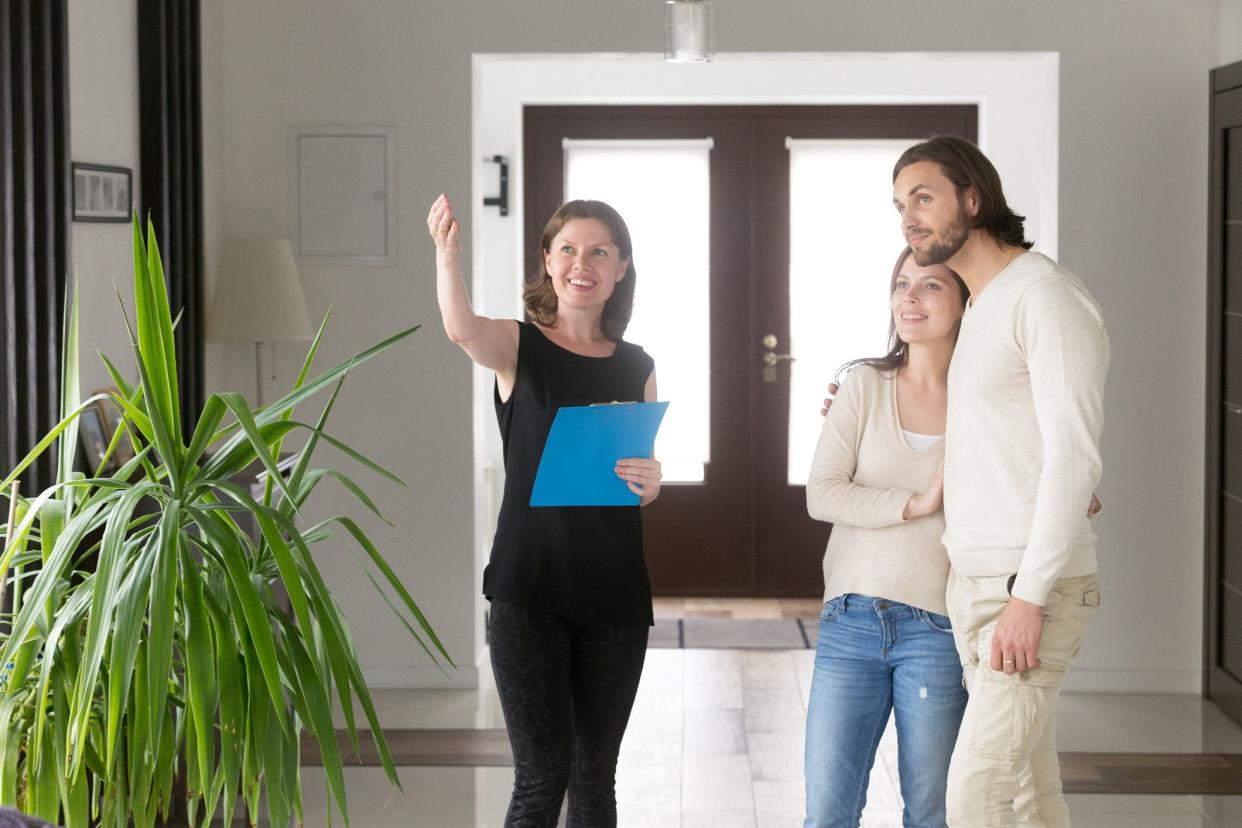 real estate agent showing home to young couple