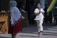 A young boy wearing a face mask to curb the spread of the coronavirus runs at a prayer ceremony to mark the holiday of "Enkutatash", the first day of the new year in the Ethiopian calendar, which is traditionally associated with the return of the Queen of Sheba to Ethiopia some 3,000 years ago, at Bole Medhane Alem Ethiopian Orthodox Cathedral in the capital Addis Ababa, Ethiopia Friday, Sept. 11, 2020. (AP Photo/Mulugeta Ayene)