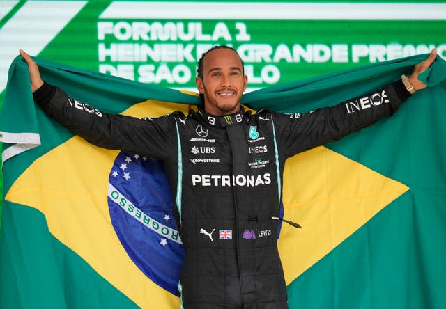 Lewis Hamilton holds a Brazilian flag after his victory