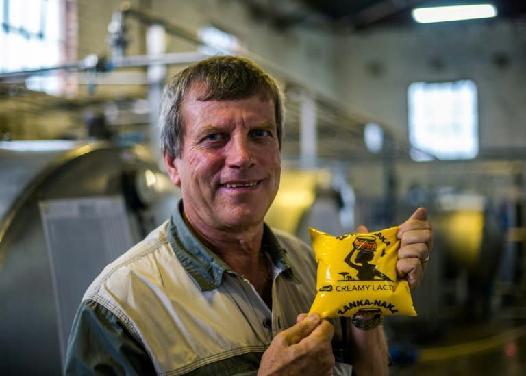 Theron holds a packet of sour milk ("maas") at his milk processing factory on November 27, 2017 in the community of Beatrice