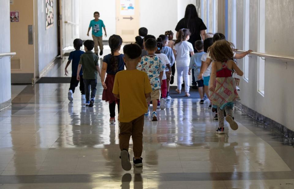 Teacher Miriam Bernal leads her transitional kindergarten class toward a restroom.