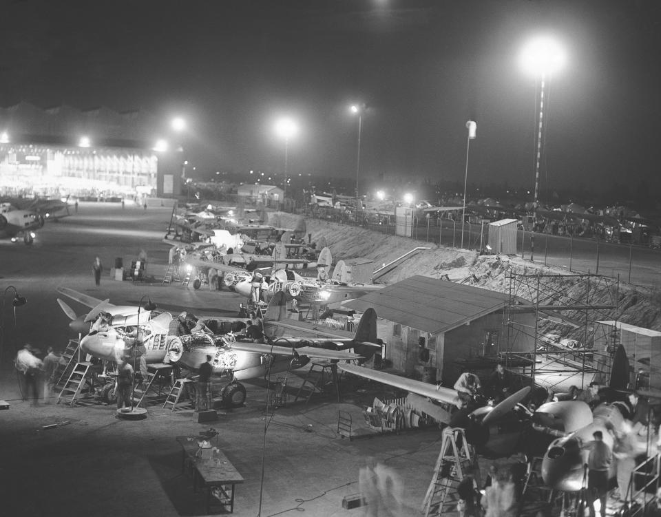 FILE - In this July 12, 1941, file photo, the final assembly of Lockheed P-38 pursuit planes at the Burbank, Calif., plant takes place outdoors under powerful floodlights, because of lack of room inside the plant. Not since World War II, when people carried Ration Books, when buying cars, firewood and nylon was restricted, when men were drafted and women volunteered in the war effort, has the entire nation been asked to truly sacrifice for a greater good. (AP Photo, File)