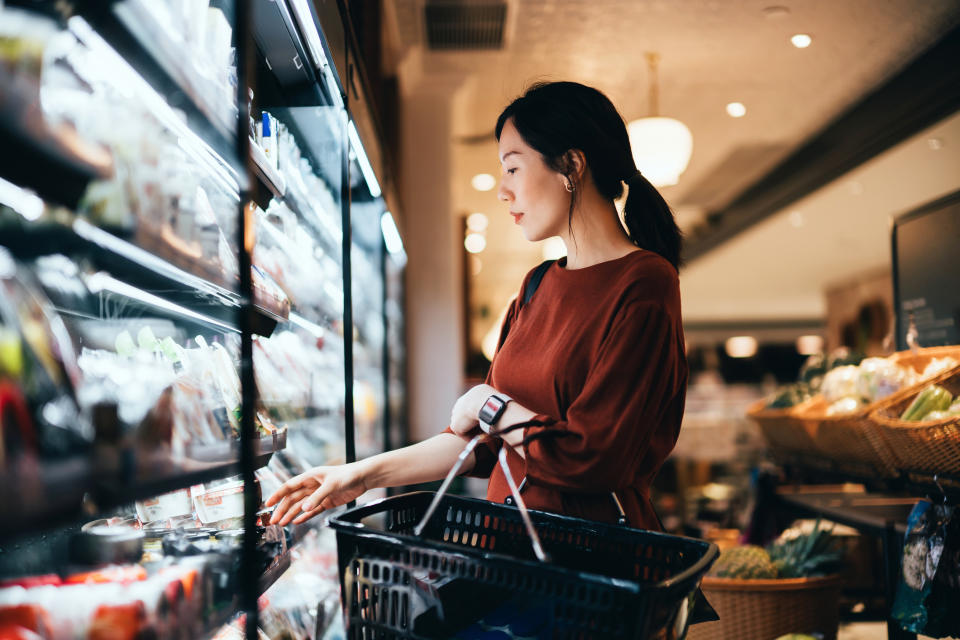 Woman in a store looking at products with a shopping basket