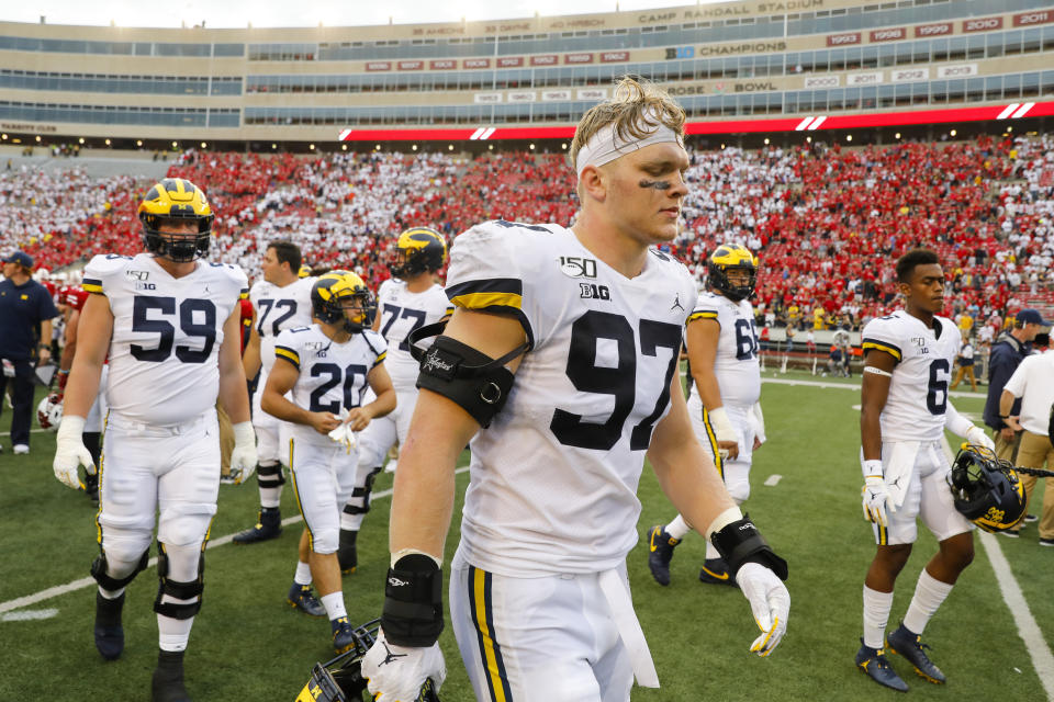 Michigan defensive lineman Aidan Hutchinson walks off the field with his teammates after losing 35-14 to Wisconsin in an NCAA college football game Saturday, Sept. 21, 2019, in Madison, Wis. (AP Photo/Andy Manis)