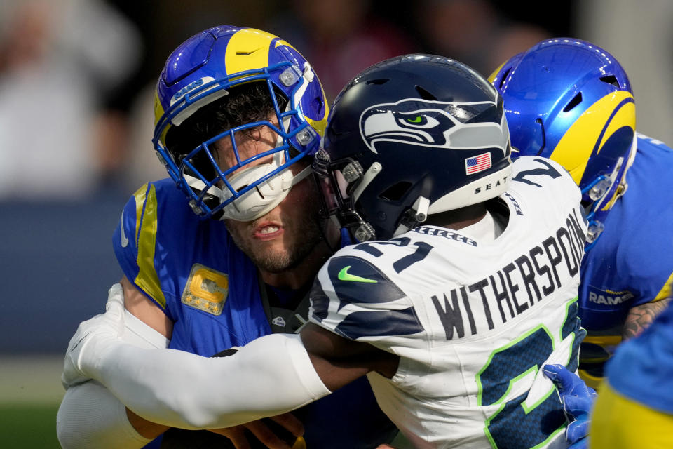 Nov 19, 2023; Inglewood, California, USA;  Seattle Seahawks cornerback Devon Witherspoon (21) sacks Los Angeles Rams quarterback Matthew Stafford (9) in the first quarter at SoFi Stadium. Mandatory Credit: Kirby Lee-USA TODAY Sports