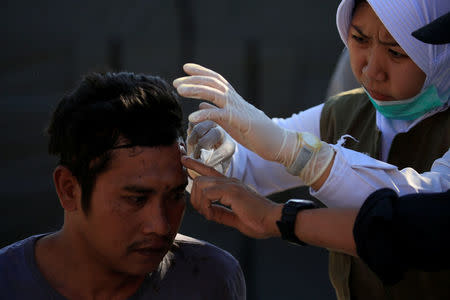 A paramedic treats an injured man outside of Tanjung hospital, after an earthquake hit in Lombok Utara, Indonesia, August 6, 2018. REUTERS/Beawiharta
