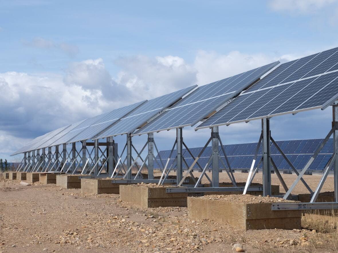 A solar array in Colville Lake, N.W.T. There is currently a 20 per cent cap on the amount of electricity solar arrays can contribute to power grids in diesel communities, but a report commissioned by the territorial government recommends increasing that cap.  (Kate Kyle/CBC - image credit)