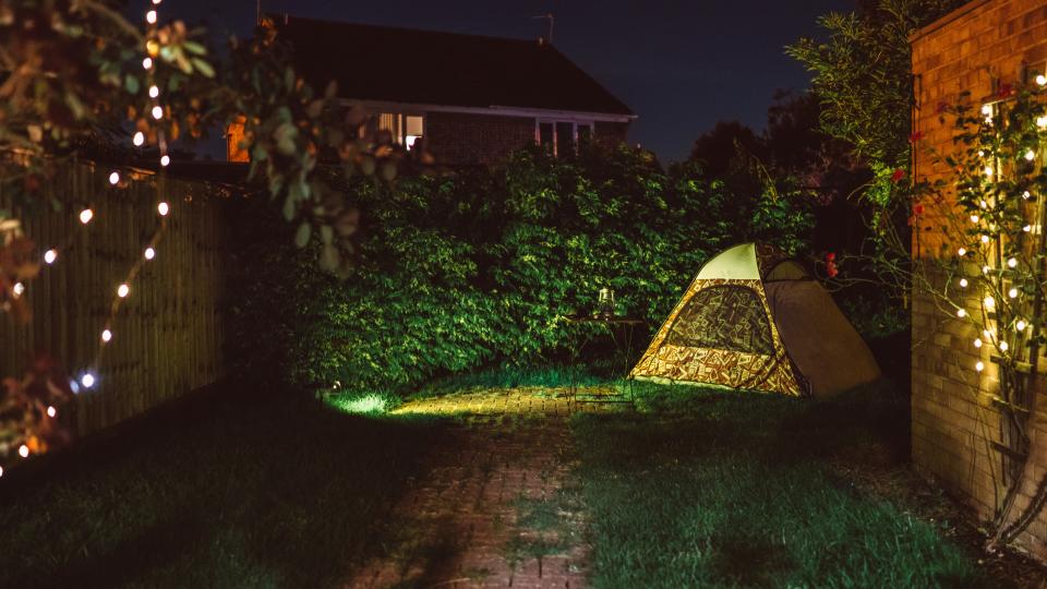 A camping tent setting in the backyard at night