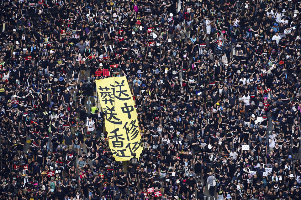 Tens of thousands of protesters carry posters and banners march through the streets as they continue to protest an extradition bill, Sunday, June 16, 2019, in Hong Kong. Hong Kong residents Sunday continued their massive protest over an unpopular extradition bill that has highlighted the territory's apprehension about relations with mainland China, a week after the crisis brought as many as 1 million into the streets. The yellow banner reads "Extradition law, funeral to Hong Kong". (Apple Daily via AP)