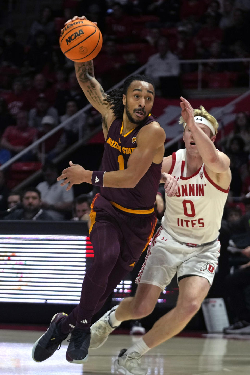 Arizona State guard Frankie Collins (1) goes to the basket as Utah guard Hunter Erickson (0) defends during the first half of an NCAA college basketball game Saturday, Feb. 10, 2024, in Salt Lake City. (AP Photo/Rick Bowmer)