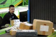 U.S. Customs and Border Protection technician Czar Zeman monitors overseas parcels as they are scanned at the agency's overseas mail inspection facility at Chicago's O'Hare International Airport Feb. 23, 2024, in Chicago. The explosive growth of cross-border e-commerce involving major China-backed players such as Shein and Temu has caught the attention of the U.S. lawmakers amid a bitter U.S.-China trade war and cast a spotlight on a tax rule that critics say has allowed hundreds of millions of China-originated packages to enter the U.S. market each year without duty and without reliable information for lawfulness. (AP Photo/Charles Rex Arbogast)