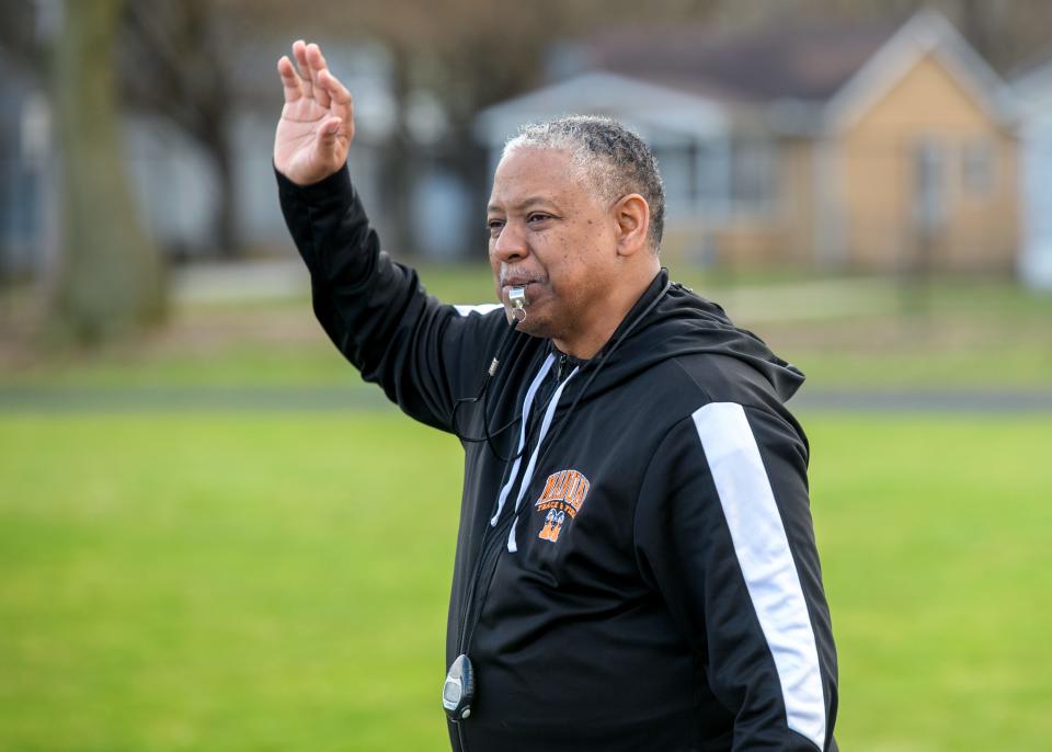 Manual High School track and field coach Harvey Burnett gets ready to start a runner during a recent practice at the South Peoria school.