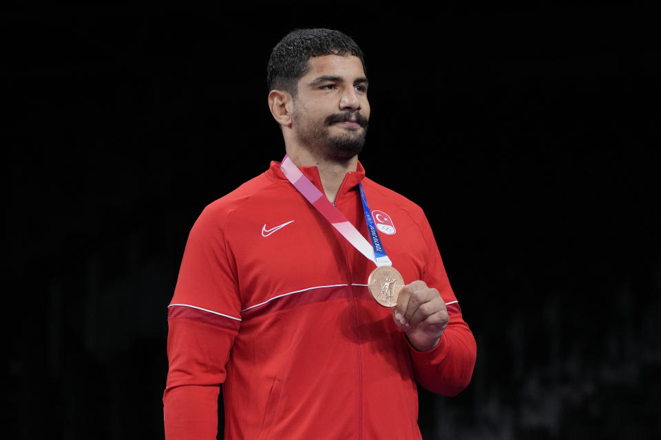 Turkey's Taha Akgul shows his bronze medal during the victory ceremony for men's freestyle 125kg wrestling at the 2020 Summer Olympics, Friday, Aug. 6, 2021, in Chiba, Japan. (AP Photo/Aaron Favila)