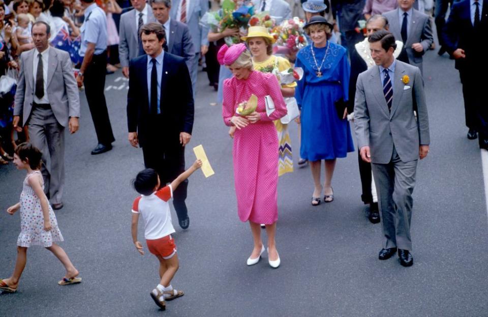 <p>Diana greets a young fan while wearing a hot-pink polka-dot outfit by Donald Campbell and John Boyd hat. </p>