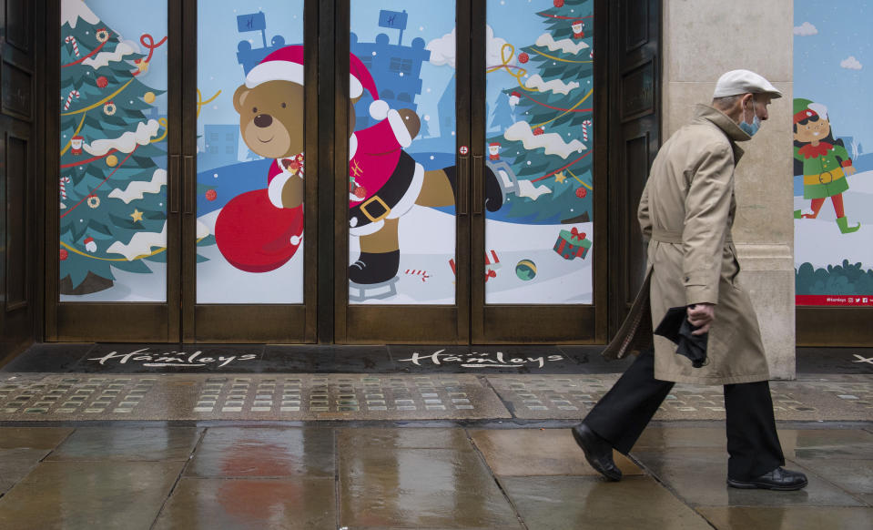 A man walks past closed shops on Regent Street, in London on Monday Dec. 21, 2020. Millions of people in England have learned they must cancel their Christmas get-togethers and holiday shopping trips. British Prime Minister Boris Johnson said Saturday that holiday gatherings can’t go ahead and non-essential shops must close in London and much of southern England. (Dominic Lipinski/PA via AP)