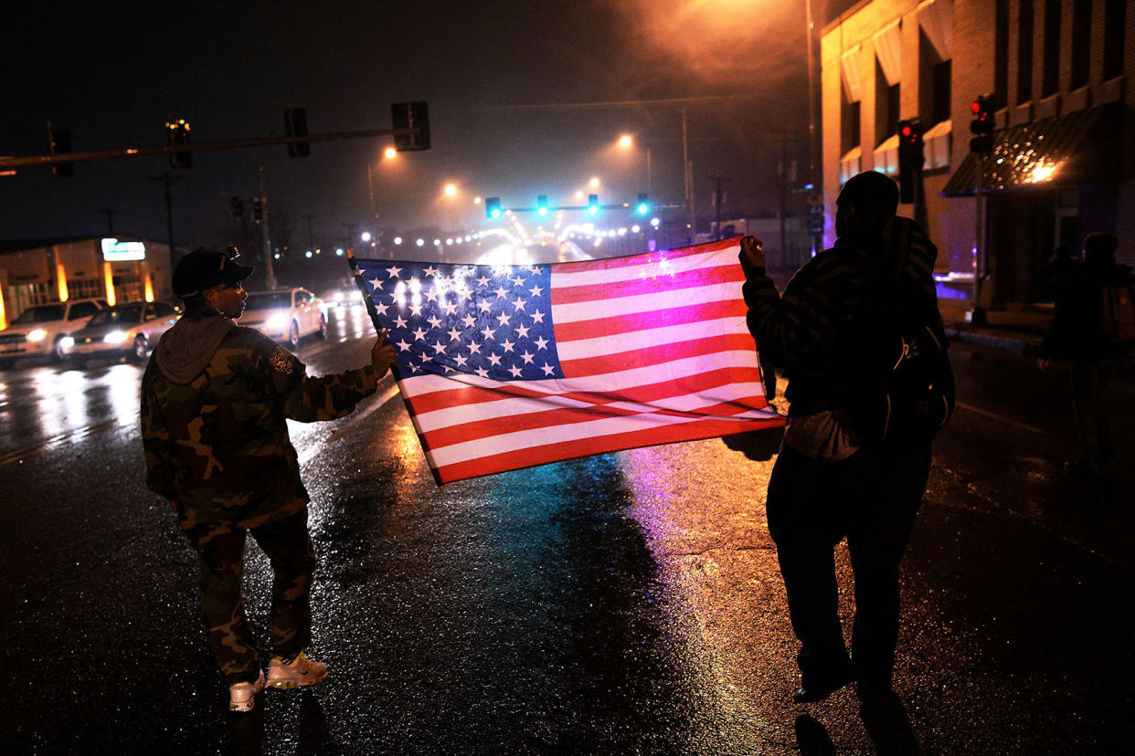 Two demonstrators march with a US flagJEWEL SAMAD/AFP via Getty Images