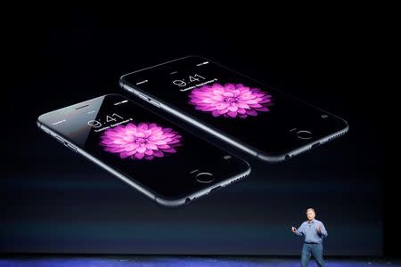 Phil Schiller, Senior Vice President at Apple Inc., speaks about the iPhone 6 (foreground) and the iPhone 6 Plus during an Apple event at the Flint Center in Cupertino, California, September 9, 2014. REUTERS/Stephen Lam