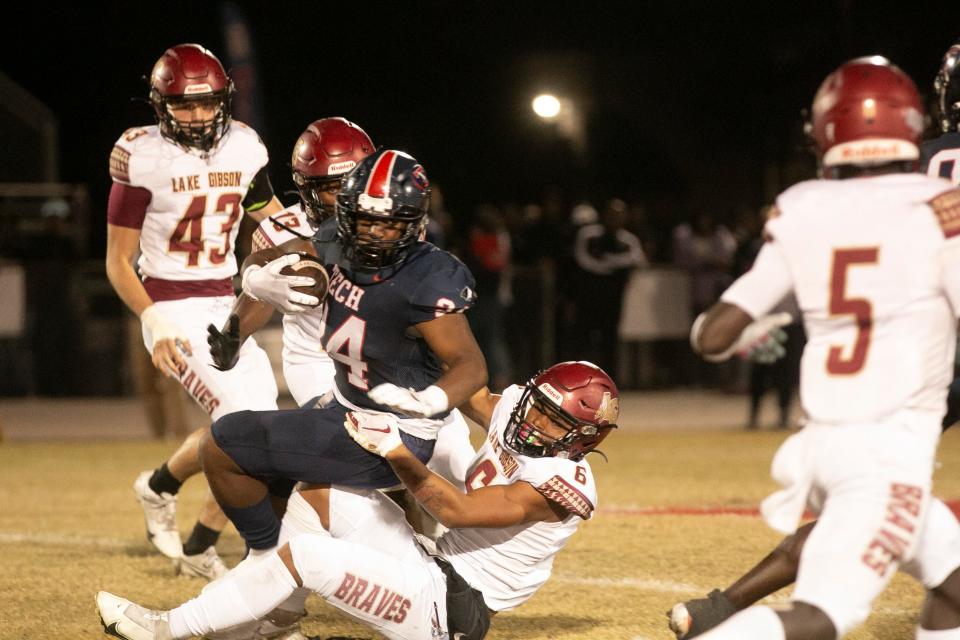 Tampa Bay Tech running back James Evans (24) is tackled by Lake Gibson's Omarion Lopez (6) during the first half.