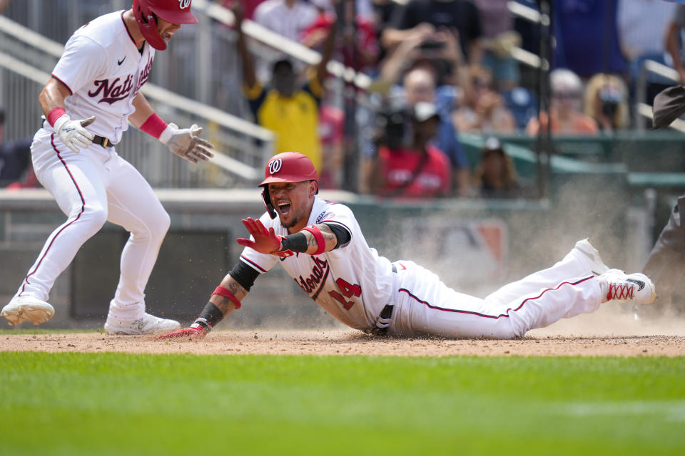 Washington Nationals' Corey Dickerson, left, celebrates as Washington Nationals' Ildemaro Vargas scores the game winning run when Milwaukee Brewers relief pitcher Devin Williams can't make the tag in time after a throwing error by Milwaukee Brewers third baseman Andruw Monasterio on a fielder's choice to the plate, during the ninth inning of a baseball game at Nationals Park, Wednesday, Aug. 2, 2023, in Washington. (AP Photo/Alex Brandon)