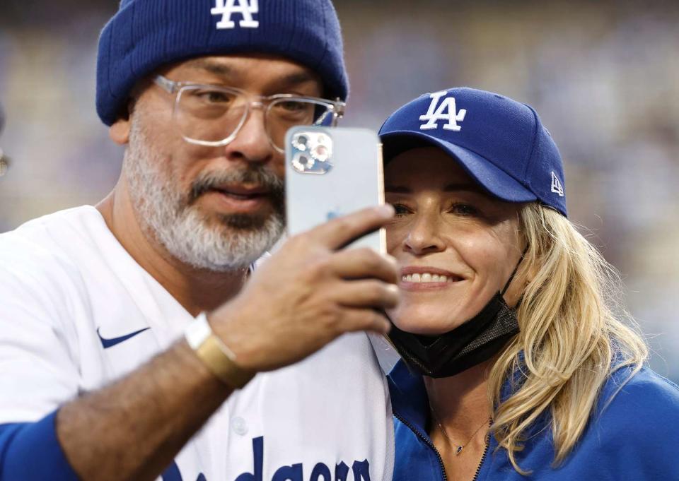 Jo Koy (L) and Comedian/actress Chelsea Handler (R) takes a selfie prior to a game between the Los Angeles Dodgers and the Atlanta Braves at Dodger Stadium on August 31, 2021 in Los Angeles, California