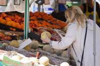 A woman checks the price of a water melon in Essen, Germany, Wednesday, May 31, 2023. German inflation eased to 6.1 % in May following several months of declines, even as Europe's biggest economy registered another painful increase in food prices of nearly 15 %. (AP Photo/Martin Meissner)