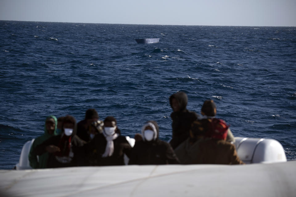 Migrants, most of them from Eritrea, are assisted by aid workers of the Spanish NGO Open Arms, after fleeing Libya on board a precarious wooden boat in the Mediterranean sea, about 110 miles north of Libya, on Saturday, Jan. 2, 2021. (AP Photo/Joan Mateu)