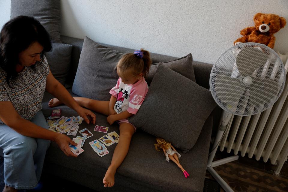 Ukrainian refugee Irina Bilenskaya, 55, plays with her grand- daughter Eva, 4, in the flat they share with other Ukrainian refugees in Madrid, Spain (REUTERS)
