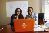 In this Thursday, May 21, 2020, photo, Jessika-Katherine Naranjo Colina, left, and Bernard Kanjoma, who co-own the graphic design and marketing firm Naranjo Designs, pose for a photo in Detroit. Kanjoma, who emigrated to the United States from Malawi, said their 12-person team has seen an 80% drop in business but they’re identifying creative ways to weather the crisis. (AP Photo/Paul Sancya)