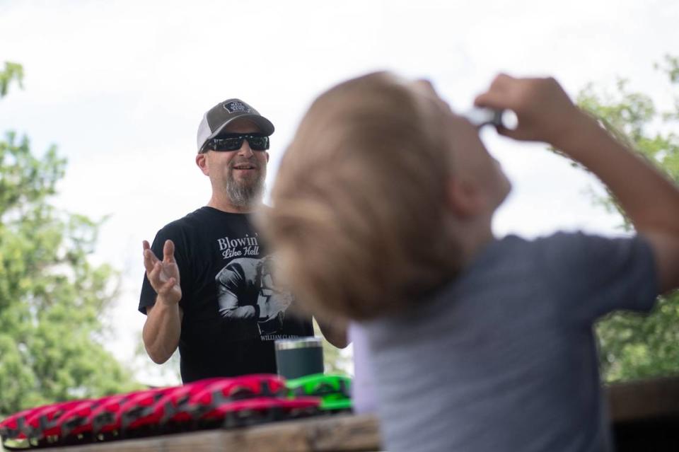 A young workshop participant tries out his harmonica during Russ “KidMan” Schenke’s Make Music Day presentation.