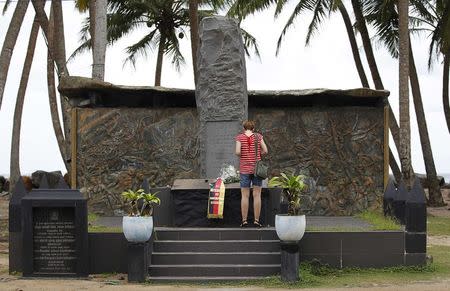 A tourist stands in front of the Tsunami memorial in Pereliya December 20, 2014. REUTERS/Dinuka Liyanawatte