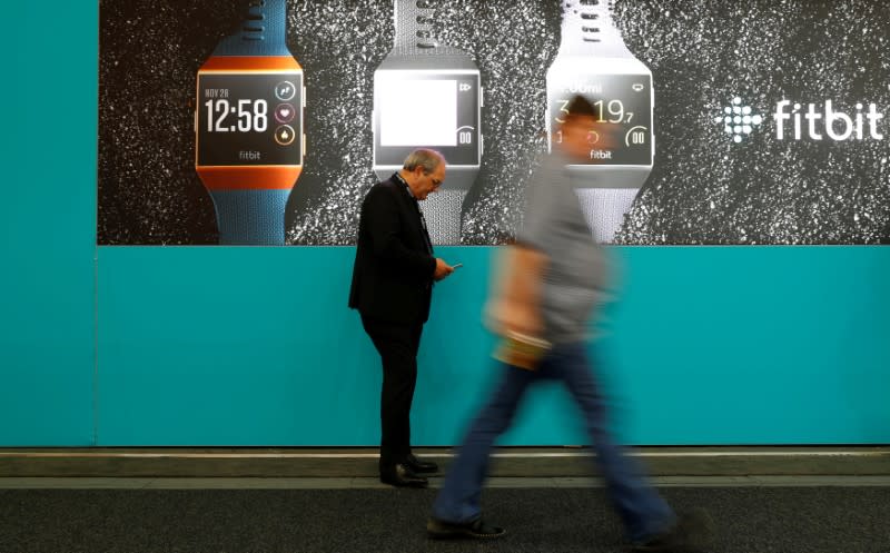 FILE PHOTO: Visitors walk past an advertising billboard for Fitbit Ionic watches at the IFA Electronics Show in Berlin