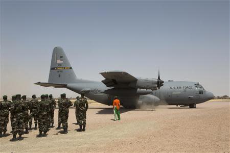 A C-130 U.S. Air Force plane lands as Nigerien soldiers stand in formation during the Flintlock military exercise in Diffa, March 8, 2014. REUTERS/Joe Penney