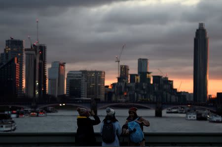 Tourists take pictures on Westminster Bridge during sunset in London, Britain, December 15, 2017. REUTERS/Clodagh Kilcoyne