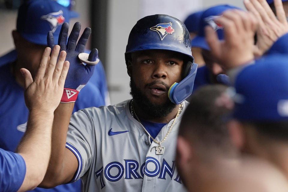 Toronto Blue Jays' Vladimir Guerrero Jr. is congratulated in the dugout for a home run against the Cleveland Guardians during the third inning of a baseball game Friday, June 21, 2024, in Cleveland. (AP Photo/Sue Ogrocki)