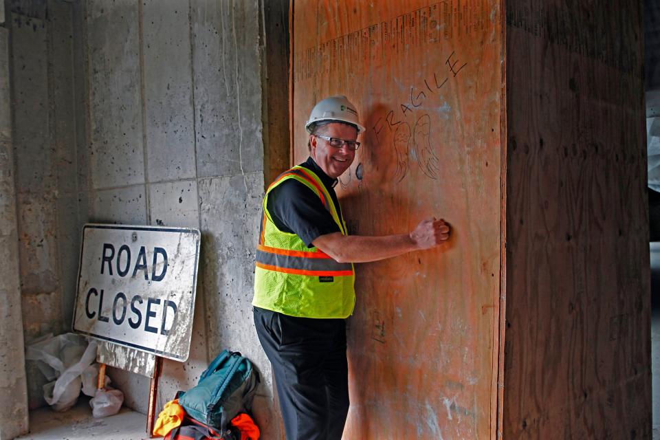 The Rev. Tim Kitzke stands next to the crate containing the statue of the archangel Gabriel in 2019 that was to be mounted on the newly rebuilt St. Rita Church.