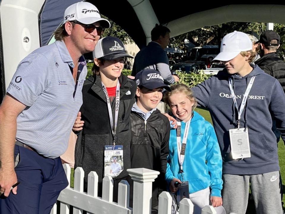 Harry Higgs poses for pictures with members of the First Tee-Golden Isles on Friday after posting a 63 at the Sea Island Club Seaside Course to earn a share of the 36-hole lead in the RSM Classic.