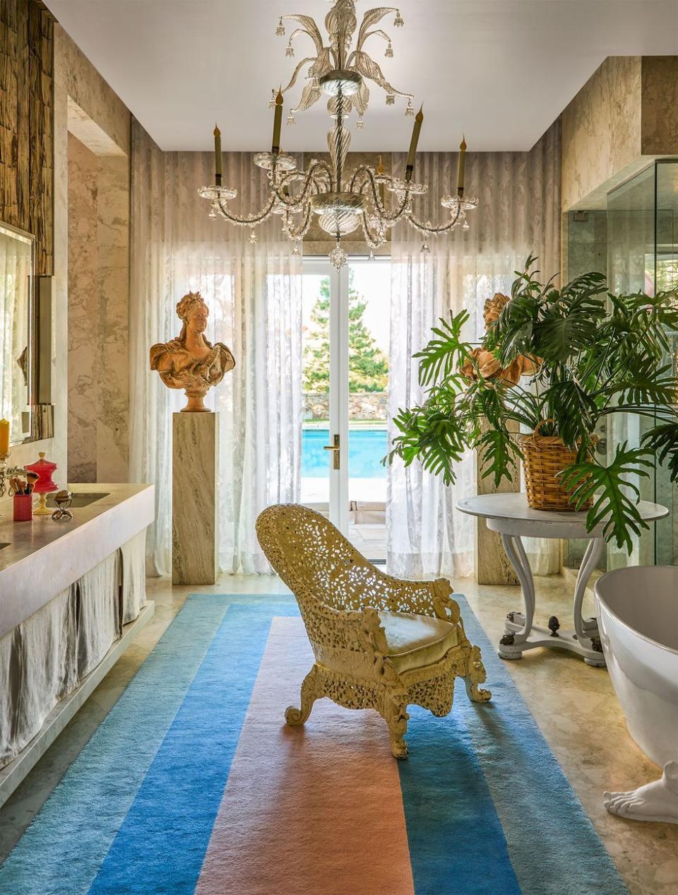 a room with a rug and a chair and a chandelier