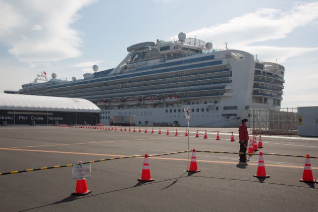 A guard stands at a restricted area in front of the Diamond Princess cruise ship in Yokohama