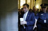 U.S. Senator Ted Cruz (C) is trailed by reporters as he arrives for a Republican Senate caucus meeting at the U.S. Capitol in Washington, October 16, 2013. REUTERS/Jonathan Ernst